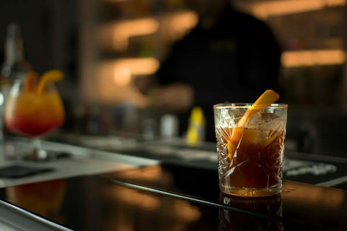 An old fashioned with an orange peel on the bar